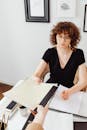 Professional woman working on paperwork, handing over documents at office desk.